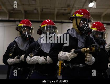 Les marins affectés au département aérien de l’USS Gerald R. Ford (CVN 78), combattent un incendie simulé lors d’un exercice de quartier général dans la baie hangar, 24 février 2022. Ford est au port de Newport News Shipyard excitant sa disponibilité incrémentale planifiée (PIA), une période de six mois de modernisation, d'entretien et de réparations. Banque D'Images