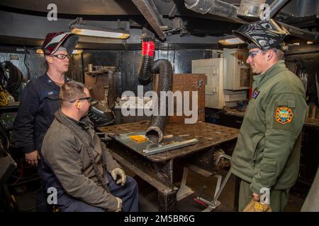 220224-N-JR318-2001 MER ADRIATIQUE (24 février 2022) le capitaine Shane Marchesi, officier exécutif du porte-avions de la classe Nimitz USS Harry S. Truman (CVN 75), parle avec les techniciens d'entretien de Hull dans l'atelier de réparation à bord de Truman, 24 février 2022. Le groupe de grève des transporteurs Harry S. Truman est en cours de déploiement aux États-Unis Sixième zone d'exploitation de la flotte à l'appui des intérêts des États-Unis, des alliés et des partenaires en Europe et en Afrique. Banque D'Images