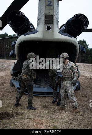 A ÉTATS-UNIS Le parachutiste affecté à l'équipe de combat de la 3rd Brigade, 82nd le poing de la Division aéroportée secoue un soldat polonais affecté à la Brigade du fusil 21st après avoir chargé son personnel sur un hélicoptère CH-47 Chinook lors d'un entraînement combiné à Nowa Deba, en Pologne, le 25 février 2022. La mission de la Division aéroportée de 82nd est d'assurer nos alliés et de dissuader l'agression russe. La division aéroportée de 82nd est actuellement déployée en Pologne pour former et opérer aux côtés de nos alliés polonais dans le cadre d'un engagement continu de l'OTAN. Banque D'Images