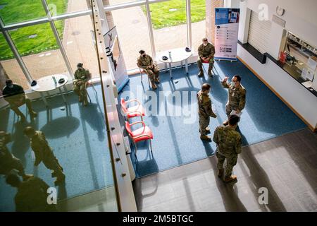Des aviateurs du 423rd e Escadron des forces de sécurité attendent dans le hall de l'escadron médical 423rd lors de leur traitement de pré-déploiement à la RAF Alconbury, en Angleterre, le 24 février 2022. Les membres du SFS se préparent à se déployer à l'appui d'une réponse conjointe pour mener des opérations axées sur le renforcement de la posture du flanc est de l'OTAN. Banque D'Images