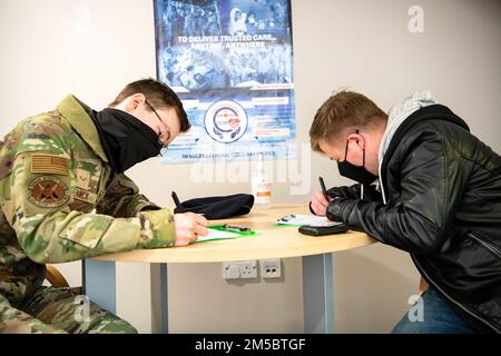 Les aviateurs de l'escadron 423rd des forces de sécurité remplissent les documents dans le cadre de leur traitement préalable au déploiement à la RAF Alconbury, en Angleterre, le 24 février 2022. Plusieurs membres du SFS se préparent à se déployer à l'appui d'une réponse conjointe pour mener des opérations axées sur le renforcement de la posture du flanc est de l'OTAN. Banque D'Images