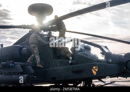 ÉTATS-UNIS Soldats de l’armée affectés à la troupe Alpha “Nightmare”, 7th escadron, 17th Cavalry Regiment, 1st Air. Brigade, 1st. La division effectue des inspections avant vol sur un Apache AH-64D avant de quitter Storck Barracks, Illesheim, Allemagne, le 24 février 2022, En route vers la Pologne. Les éléments de 1ACB ont été invités à se repositionner pour soutenir la décision des États-Unis d’accroître leur présence et leurs activités en Europe dans le cadre de notre engagement ferme et inlassable envers nos alliés et partenaires de l’OTAN. Banque D'Images