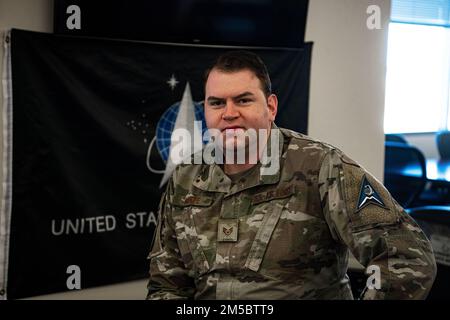 BASE DE FORCE SPATIALE SCHRIEVER, COLORADO - ÉTATS-UNIS Personnel de la Force aérienne. Le Sgt Justin Sroufe, chef de l'équipage de communications par satellite de l'escadron 4th de l'opération spatiale, pose par un drapeau de la Force spatiale à la base de la Force spatiale de Schriever, Colorado, le 24 février 2022. Sroufe a été l'un des premiers chefs d'équipage de l'ONC sur la surface des opérations et a été reconnu comme l'officier non commandant de l'année 2021 4th DES OÉP. Banque D'Images