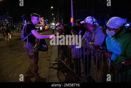 (Mobile, AL) : SPC. Johnathan Schramm, saxaphone pour la bande de l'Armée de terre 151st, remet des cadeaux à la foule sur le thème de la Garde nationale lors de la parade des strippers de Mystic, Mardi gras, 24th février 2022. Mobile, lieu de naissance des Mardi gras américains, organise presque des défilés nocturnes pendant la saison des Mardi gras, la plupart des défilant attirant des foules de 10 000 personnes. Banque D'Images