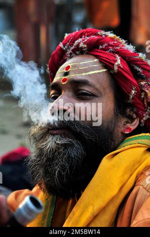 Un chillum fugeant Shaivite sadhu sur le Mallick Ghat près de la rivière Hooghly à Kolkata, en Inde. Banque D'Images