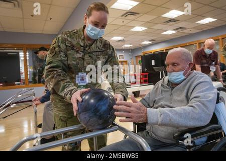 ÉTATS-UNIS Le Sgt. Kara Kauffman, Squadron de maintenance, 177th Fighter Wing, Garde nationale aérienne du New Jersey, remet une balle de bowling à Fred Malone Jr., résident du New Jersey Veterans Memorial Home à Vineland, dans la piste de bowling de Home à Vineland, New Jersey, le 24 février 2022. Kauffman dessert les résidents de la Maison dans le département d'enrichissement de la vie. Plus de 70 soldats et aviateurs de la Garde nationale du New Jersey sont des assistants infirmiers certifiés et travaillent dans les services alimentaires, le contrôle des infections, la technologie de l'information, l'enrichissement de la vie, la logistique, Et test COVID-19. (New Jersey Natio Banque D'Images