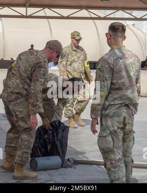 Les membres de l'équipe d'inspection de l'escadre expéditionnaire aérienne 380th simulent une explosion tout en pratiquant des compétences de développement de préparation au combat à la base aérienne Al Dhafra, aux Émirats arabes Unis, sur 24 février 2022. L’équipe d’inspection de l’escadre, établie par le bureau de l’inspecteur général, a pour mission de fournir au commandant de l’escadre expéditionnaire aérien de 380th un programme complet d’inspection et de préparation en effectuant des inspections approfondies, en élaborant et en exécutant des exercices de préparation réalistes et en atténuant le risque de non-conformité non détectée. Banque D'Images