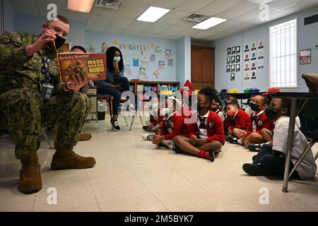 WHISTLER, Alabama (25 févr. 2022) classe 2nd de technicien en systèmes d'information Kevin Cournoyer lit aux élèves de l'école préparatoire de Prichard pendant la semaine de la marine mobile, le 25 février. La semaine de la Marine est une série annuelle d'événements qui se tiennent tout au long de l'année dans diverses villes des États-Unis sans présence importante de la Marine pour offrir aux citoyens l'occasion d'interagir avec les marins et d'en apprendre davantage sur la Marine et ses capacités. Banque D'Images