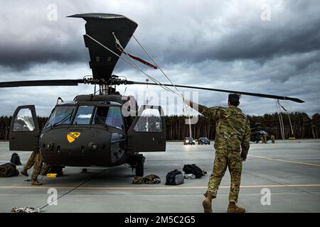 ÉTATS-UNIS Les soldats affectés à la Force opérationnelle de Palehorse, au sein de l'escadron 7th, du 17th Cavalry Regiment, de la 1st Air Cavalry Brigade, effectuent des vérifications et des services d'entretien préventif (MCS) sur les hélicoptères AH-64 Apaches et UH-60 Blackhawks en Pologne, le 25 février 2022. LES PMC sauvent des vies sur le champ de bataille et sont un élément essentiel de la préparation au combat. Banque D'Images