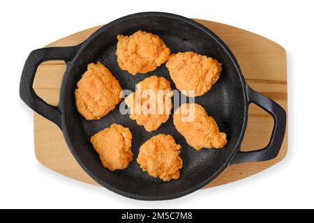 Vue de dessus des pilons de poulet surgelés semi-finishés dans une poêle en fonte Banque D'Images