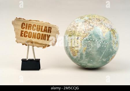 Concept d'entreprise et d'industrie. Près du globe il y a un clip avec une plaque de carton sur laquelle il est écrit - économie circulaire Banque D'Images