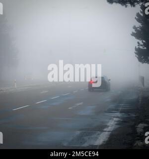 Mauvais temps conduire - foggy brumeux country road. L'autoroute - la circulation routière. L'heure d'hiver. Banque D'Images