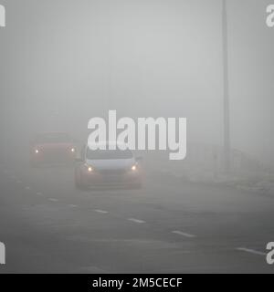 Mauvais temps conduire - foggy brumeux country road. L'autoroute - la circulation routière. L'heure d'hiver. Banque D'Images