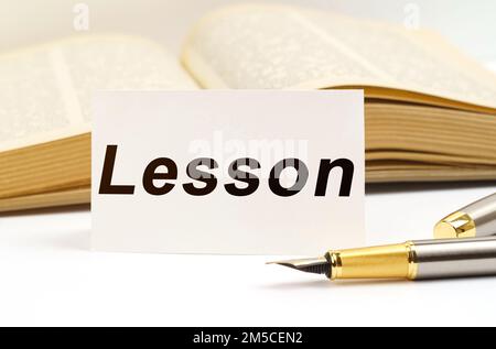 Concept d'éducation. Sur le fond du livre se trouve un stylo et une carte de visite avec l'inscription - leçon Banque D'Images