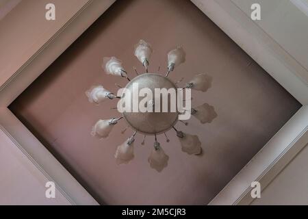 un lustre blanc est suspendu au plafond pendant la mi-journée Banque D'Images