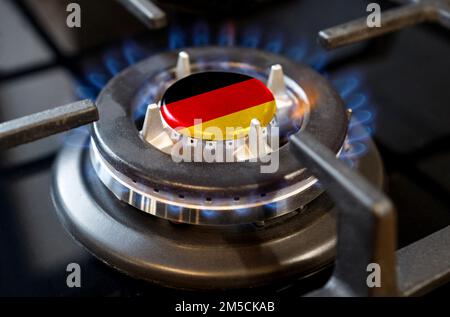 Concept d'importation et d'exportation de gaz. Un brûleur à gaz brûlant d'un poêle à la maison, au milieu duquel est représenté un drapeau - Allemagne Banque D'Images