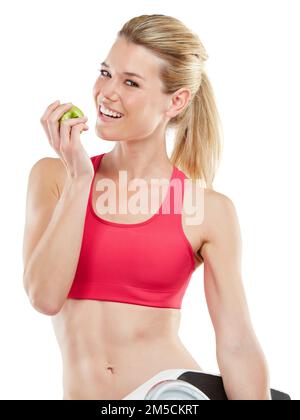 La santé est une relation entre vous et votre corps. Photo en studio d'une jeune femme athlétique mangeant une pomme. Banque D'Images