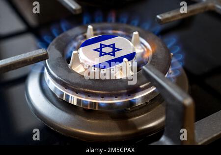 Concept d'importation et d'exportation de gaz. Un brûleur à gaz brûlant d'un poêle à la maison, au milieu duquel est représenté un drapeau - Israël Banque D'Images