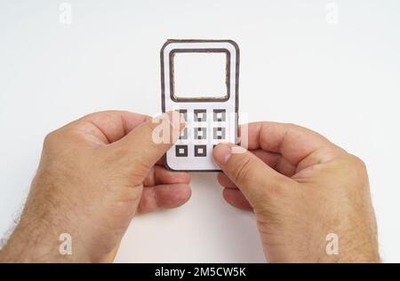 Un homme a un téléphone portable en carton dans ses mains. Il appuie sur les boutons. Concept de technologie Banque D'Images