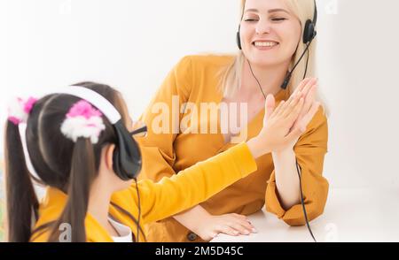 Leçon privée. Une jeune femme attentionnée enseignant aide petite fille élève à étudier le langage mathématique corriger les erreurs expliquer le matériel d'apprentissage Banque D'Images