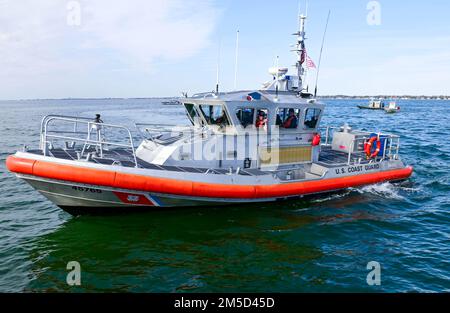 Un bateau-Medium de 47 pieds de la station de garde côtière Portsmouth et d'autres équipages de petits bateaux participants se positionnent pour assister à une démonstration en direct d'hélicoptère d'action dans le cadre du forum régional de recherche et de sauvetage organisé à Hampton, en Virginie, le 3 mars 2022. Le Forum SAR est un événement annuel qui continue de renforcer les partenariats et les communications interagences régionales, ainsi que d'améliorer les processus et les compétences nécessaires pour sauver des vies des organismes de recherche et de sauvetage. Photo de la Garde côtière américaine par Petty Officer 1st classe Stephen Lehmann. Banque D'Images