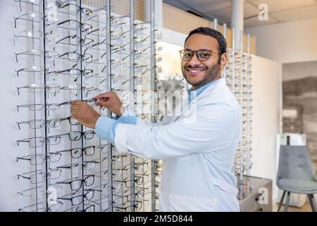 Souriant homme consultant en blouse de laboratoire vendant des lunettes Banque D'Images