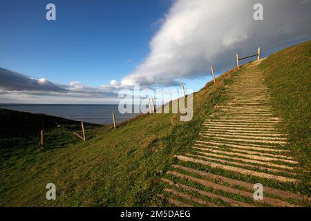 Le sentier côtier s'élevant à Dinas Dinlle Iron Age colline. Au sud de la plage Dinlle de Dinas, près de Caernarfon. Gwynedd, pays de Galles du Nord, Royaume-Uni Banque D'Images