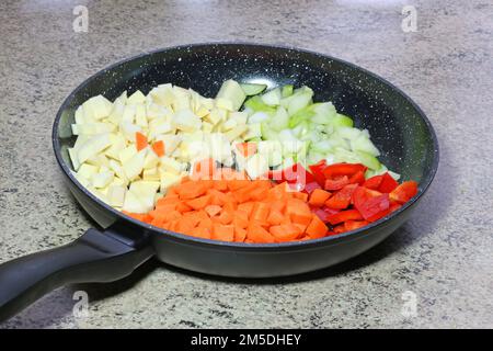 Faire cuire les légumes dans une poêle prête à cuire. Banque D'Images