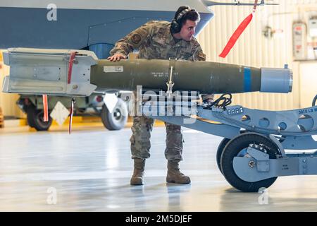 ÉTATS-UNIS L'avionneur principal de la Force aérienne Aaron Campbell, 12th, unité de maintenance des aéronefs, membre de l'équipage de chargement d'armes de l'escadron de maintenance des opérations spéciales 727th, manœuvre une bombe vers un avion pilote à distance MQ-9 Reaper lors de la compétition de l'équipage de chargement annuel 27th du Groupe de maintenance des opérations spéciales 2021 à la base aérienne de Cannon, Nouveau-Mexique, 4 mars 2022. La compétition a opposé un équipage de l'UMA de 12th chargé des munitions sur une MQ-9 contre un équipage de l'unité de maintenance des aéronefs de 16th, 27th escadron de maintenance des aéronefs d'opérations spéciales chargeant des munitions sur un AC-130W Stinger II Banque D'Images