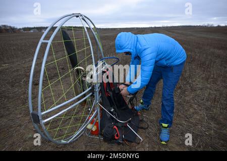 Paramétrage. Homme paramotoriste préparant le paramoteur pour le vol. Kiev, Ukraine Banque D'Images