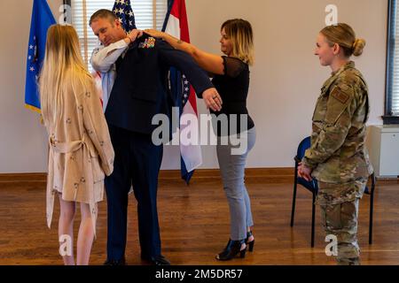 Le sergent-chef William McGurgan, chef des opérations de la défense, gestionnaire enrôlisé, vol de communication de la 131st, Escadre Bomb, donne ses nouveaux chevrons avec l'aide de sa femme et de ses filles lors de sa cérémonie de promotion, 5 mars 2022, à la Garde nationale aérienne Jefferson Barracks, St. Louis, Missouri. McGurgan a eu beaucoup de famille et d'amis viennent montrer le soutien pendant sa promotion. Banque D'Images