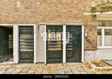 un vieux bâtiment avec deux portes et quelques feuilles sur le sol en face de la porte sont cassés, mais il n'y a personne Banque D'Images