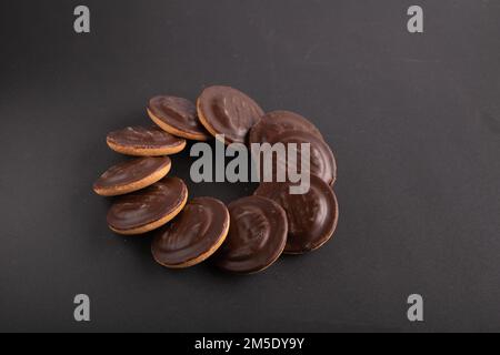 des cookies enrobés de chocolat sur fond noir Banque D'Images