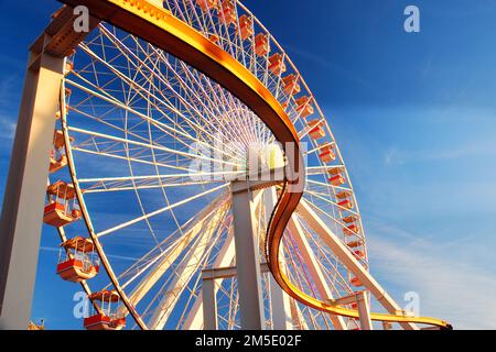 Un rail courbe coupe devant une grande roue de Ferris Banque D'Images