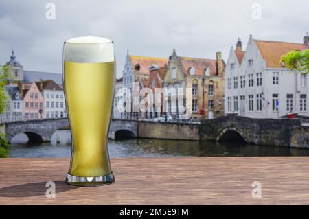 Verre de bière légère sur table en bois avec vue sur le canal et la rue à Bruges, Belgique Banque D'Images