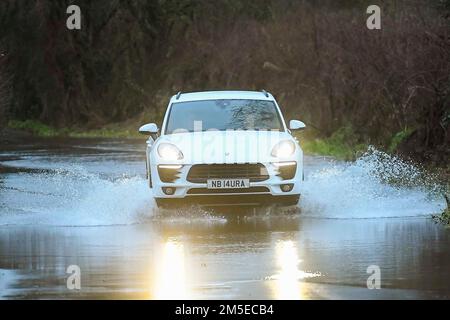 Muckleford, Dorset, Royaume-Uni. 28th décembre 2022. Météo Royaume-Uni. Une voiture traverse les eaux de crue sur une route à Muckleford près de Dorchester dans Dorset après une journée de fortes pluies et de vents violents. Crédit photo : Graham Hunt/Alamy Live News Banque D'Images