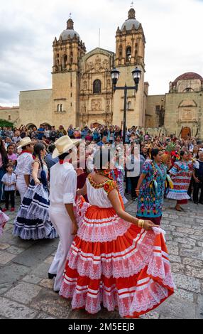 Danseurs en robe traditionnelle de Santiago Pinotepa Nacional dans un défilé de Guelaguetza à Oaxaca, Mexique. Derrière se trouve l'église de Saint-Domingue de Guzm Banque D'Images