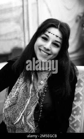 Une jeune femme qui regarde beaucoup une photo hippy c1970 par Tony Henshaw Banque D'Images