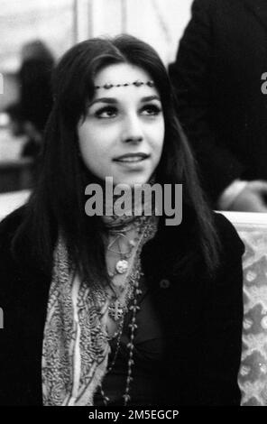 Une jeune femme qui regarde beaucoup une photo hippy c1970 par Tony Henshaw Banque D'Images