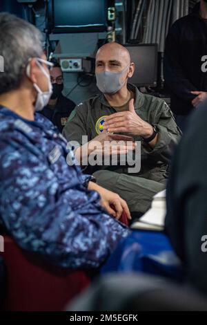 OCÉAN PACIFIQUE (7 mars 2022) le capitaine Greg Baker, au centre à droite, commodore de l'escadron amphibie Eleven, dirige un mémoire avec la Force d'autodéfense du Japon, à bord du navire d'assaut amphibie déployé par l'avant USS America (LHA 6). L'Amérique, navire chef de file du America Amphiobie Ready Group, ainsi que l'unité expéditionnaire maritime 31st, opère dans la zone de responsabilité de la flotte américaine 7th afin d'améliorer l'interopérabilité avec les alliés et les partenaires et de servir de force de réaction prête à l'emploi pour défendre la paix et la stabilité dans la région Indo-Pacifique. Banque D'Images