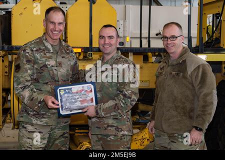 Le colonel Matt Husemann, à gauche, commandant de l'escadre du 436th Airlift, présente Tech. Sergent Tyler Barresi, officier responsable de l’entretien polyvalent de l’escadron de préparation logistique 436th, avec une pièce de monnaie et un certificat comme meilleur exécutant de la semaine à la base aérienne de Douvres, Delaware (8 mars 2022). Barresi a également reçu une pièce de monnaie par le Sgt. Timothy Bayes, chef de commandement de 436th AW, pour son rendement exceptionnel. Banque D'Images