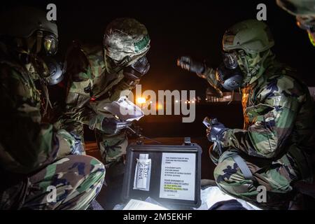 Airman 1st classe Samuel Hill, à gauche, Tech. Le Sgt Gary Crawford, au milieu, et le Sgt Michael Barrett, à droite, 909th chefs d'équipage de l'unité de maintenance des aéronefs, ouvrent la trousse de décontamination et examinent la liste de contrôle pour la décontamination d'un stratosant KC-135 contaminé lors d'une attaque chimique simulée, au cours d'un exercice de formation axé sur la mission à la base aérienne de Kadena, au Japon, au 8 mars 2022. L’unité de maintenance des aéronefs 909th joue un rôle essentiel en s’assurant que les stratotankers KC-135 de l’escadron de ravitaillement aérien 909th sont prêts à effectuer des missions de ravitaillement en vol à tout moment, permettant ainsi à l’aviation américaine de voler plus loin Banque D'Images