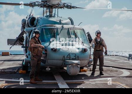 220308-N-GF955-1146 MER DES CARAÏBES - (le 8 mars 2022) -- le lieutenant Kyle « Sunshine » Suhrie, à gauche, Et Naval Air Crewman (hélicoptère) 2nd classe Dennis Cody, affecté à la "Shadow Det" de l'Escadron de combat de la mer (HSC) 28, détachement 7, effectuent des contrôles en vol pendant une évolution de ravitaillement sur le pont de vol du navire de combat littoral Freedom-variant USS Billings (LCS 15), le 8 mars 2022. Billings est déployé dans la zone d’opérations de la flotte américaine 4th afin d’appuyer la mission de la Force opérationnelle interagences conjointe Sud, qui comprend des missions de lutte contre le trafic illicite de drogues dans les Caraïbes et dans le Pacifique oriental Banque D'Images