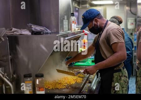 220308-N-FA490-1003 APRA HARBOUR, Guam (8 mars 2022) – Spécialiste culinaire 2nd classe Anthony Hallback, de Bronx, New York, prépare le maïs dans la galette du navire de combat littoral Independence-variant USS Jackson (LCS 6). Attaché au destroyer Squadron (DESRON) 7, Jackson est en cours de déploiement par rotation dans la zone d'opérations de la flotte américaine 7th afin de soutenir la sécurité et la stabilité dans la région, Et de travailler aux côtés des marines alliées et partenaires pour assurer la sécurité et la stabilité maritimes, les piliers essentiels d'une Indo-Pacifique libre et ouverte. Banque D'Images