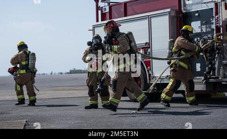 ÉTATS-UNIS Les pompiers de la Force aérienne affectés à l'escadron du génie civil 18th préparent un tuyau pour un incendie structural simulé au cours de l'entraînement de préparation de routine à la base aérienne de Kadena, au Japon, en 9 mars 2022. La formation évalue la capacité de Kadena à remplir sa mission, assurant la stabilité et la sécurité d'une Indo-Pacifique libre et ouverte. Banque D'Images