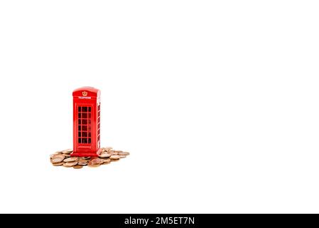 Téléphone rouge guichet argent Londres, banque de penny ou de piggy sur des pièces de monnaie sur fond blanc. Idée de réaliser des économies photo hd. Pièces de monnaie et caisse d'épargne. Banque D'Images