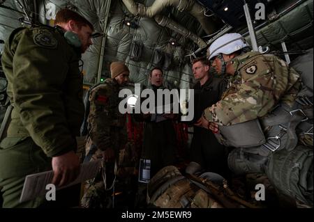 Le capitaine de la Royal Canadian Air Force Jake Balfe (au centre), un premier officier de l'ARC CC-130J Hercules affecté à l'escadron de transport 436, donne un mémoire de mission aux membres de l'équipage et aux États-Unis Soldats de l'armée, affectés au 1st Escadron, 40th Cavalry Regiment, 4th Brigade, 25th Infantry Division, États-Unis Armée Alaska, avant de sauter dans le joint Pacific multinational Readiness Centre 22-02 sur la base conjointe Elmendorf-Richardson, AK, 9 mars 2022. Le JPMRC 22-02 est la première rotation du Centre régional d'entraînement au combat (HS-CTC) en Alaska. Il se concentre sur les opérations de combat à grande échelle (LSCO) et est un C. Banque D'Images