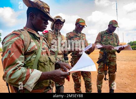 Des officiers du bataillon de parachutistes du BENIN 1st passent en revue l'ordre de leurs opérations (OPORD) avant d'informer leurs soldats au cours de l'entraînement conjoint en échange combiné (JCET) à Ouassa, Bénin, 09 mars 2022. Nous nous entraînons aux côtés de nos partenaires pour apprendre les uns des autres et partager les leçons apprises. Banque D'Images