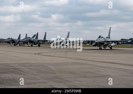 ÉTATS-UNIS Les aigles de frappe F-15E de la Force aérienne, affectés à l'escadron de combat 494th, et les faucons de combat F-16C affectés à l'escadron de combat 510th sont mis en file d'attente sur une plaque d'armement avant le décollage à la Royal Air Force Lakenheath, en Angleterre, en 9 mars 2022. La Fighter Wing Wing 48th, unité hôte de la RAF Lakenheath, travaille régulièrement aux côtés d’unités partenaires à travers l’Europe afin d’améliorer l’interopérabilité et de renforcer l’alliance transatlantique. Banque D'Images