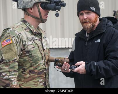 Un soldat de l'équipe de combat de la Brigade 2nd, 10th Mountain Division, teste les capacités de l'ENVG-B L3Harris avec l'aide de son instructeur à l'extérieur du bâtiment d'intégration de la Force à fort Drum, N.Y., 9 mars 2022. L'ENVG-B est une binoculaire de vision nocturne améliorée montée sur le combat avancé ainsi qu'une fixation binoculaire distante montée sur l'arme. Banque D'Images